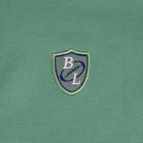 Polo homme vert au col rayé contrasté BACK to LEGEND (zoom sur le badge poitrine)